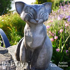 simple clay sculpture of cat sitting in sun